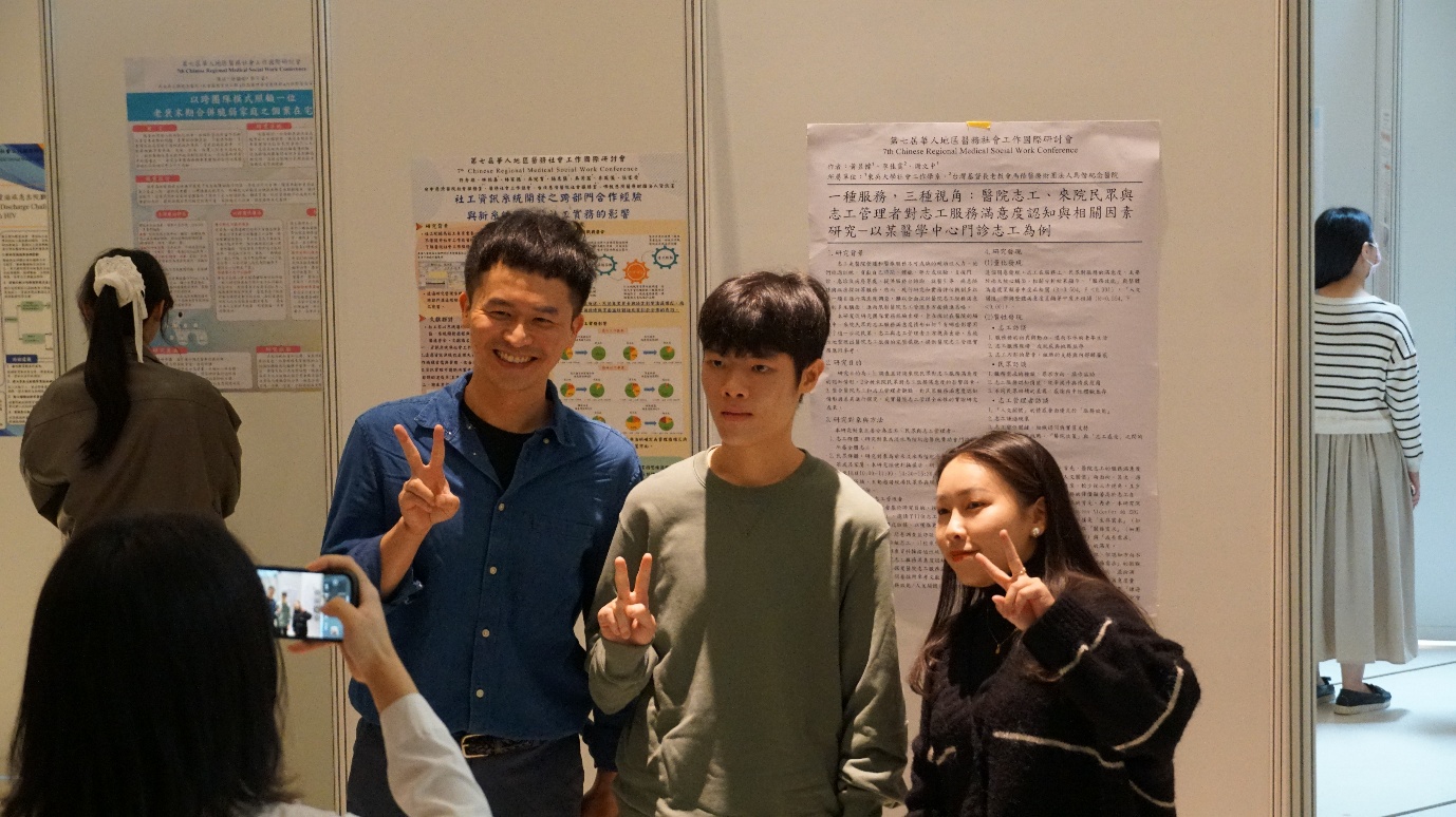 會場設置海報展示區，與會工作者於海報前合影留念。