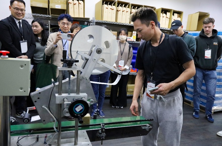 忠欣智慧倉儲物流中心進行現場作業示範，學生近距離專注觀摩智慧物流實務運作