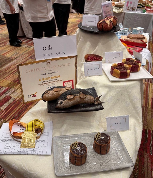 王知與同學以「臺南-以台南人一天的飲食」為主題,結合在地飲食文化與創意烘焙技術,作品包含魚形麵包及多款特色造型烘焙作品,榮獲2026臺南美食之都世界餐飲藝術挑戰賽金牌。